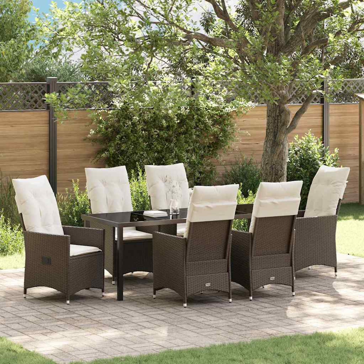 Ein Terrassenset mit einem dunklen Tisch und sechs Stühlen mit cremefarbenen Kissen steht auf einer Ziegelterrasse, umgeben von Grün.