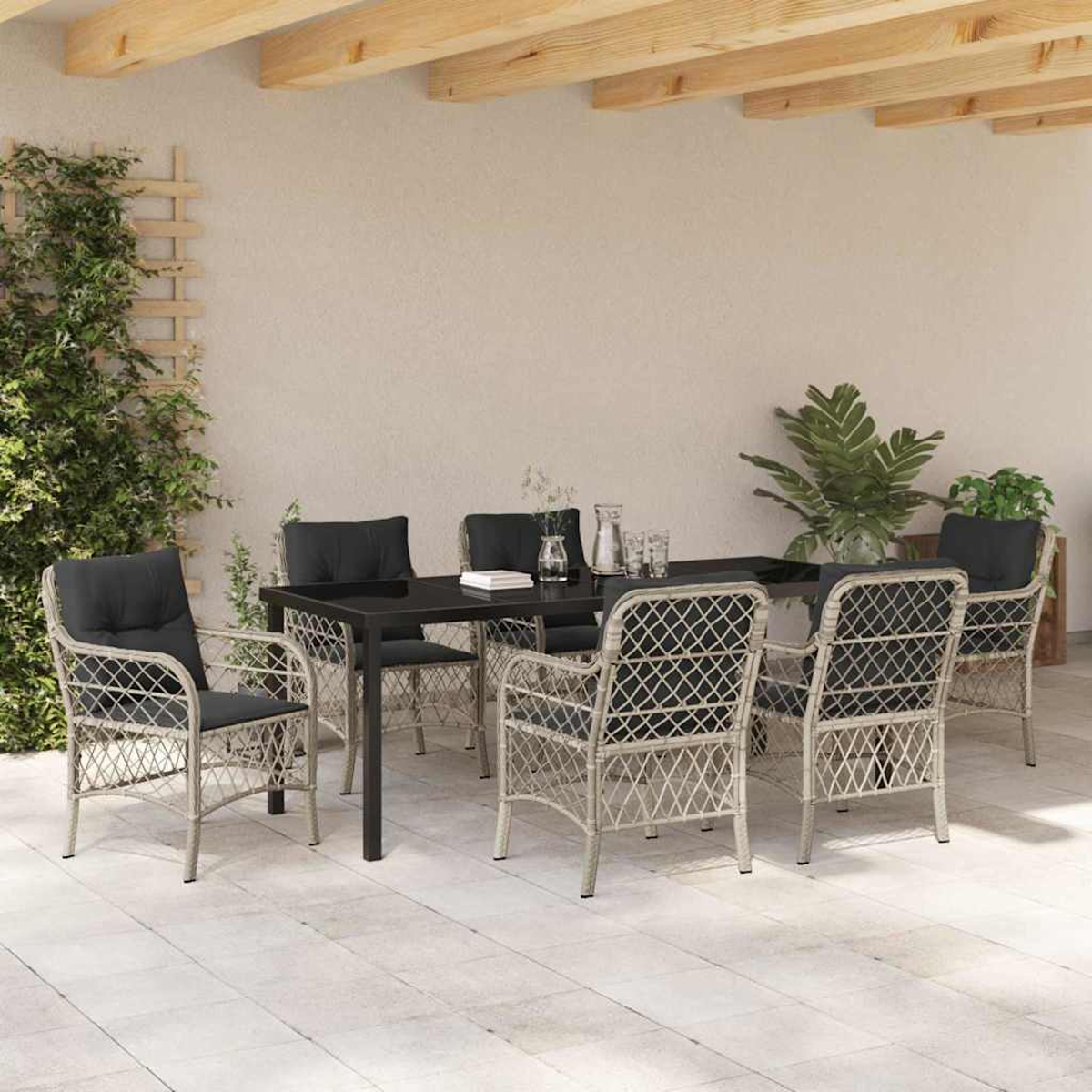 Essgruppe im Freien mit schwarzem Tisch, sechs Stühlen und Zierpflanzen. Beige Stühle mit schwarzen Kissen.