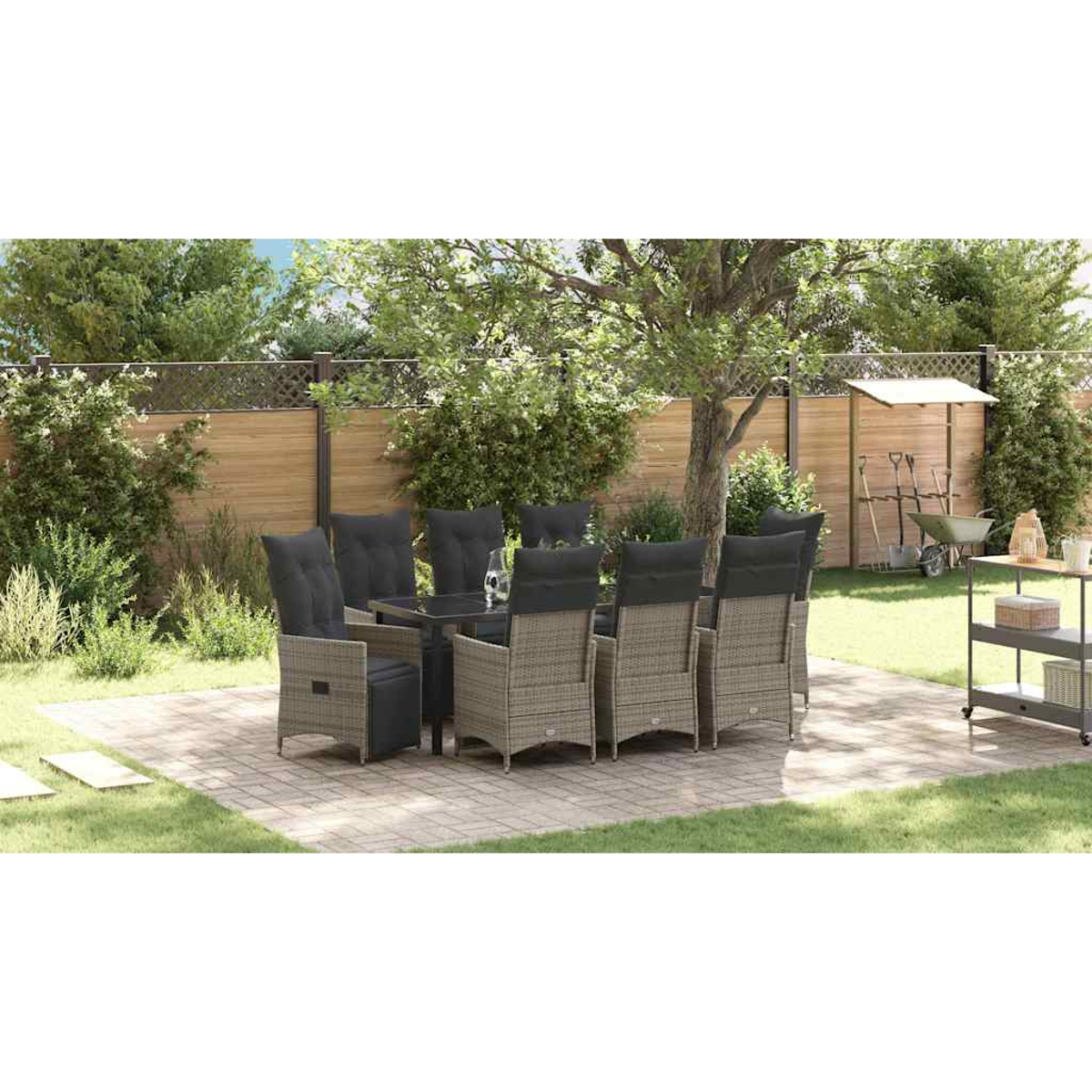Essgruppe im Freien auf einer Terrasse. Enthält einen Tisch, Stühle und Gartengeräte im Hintergrund.