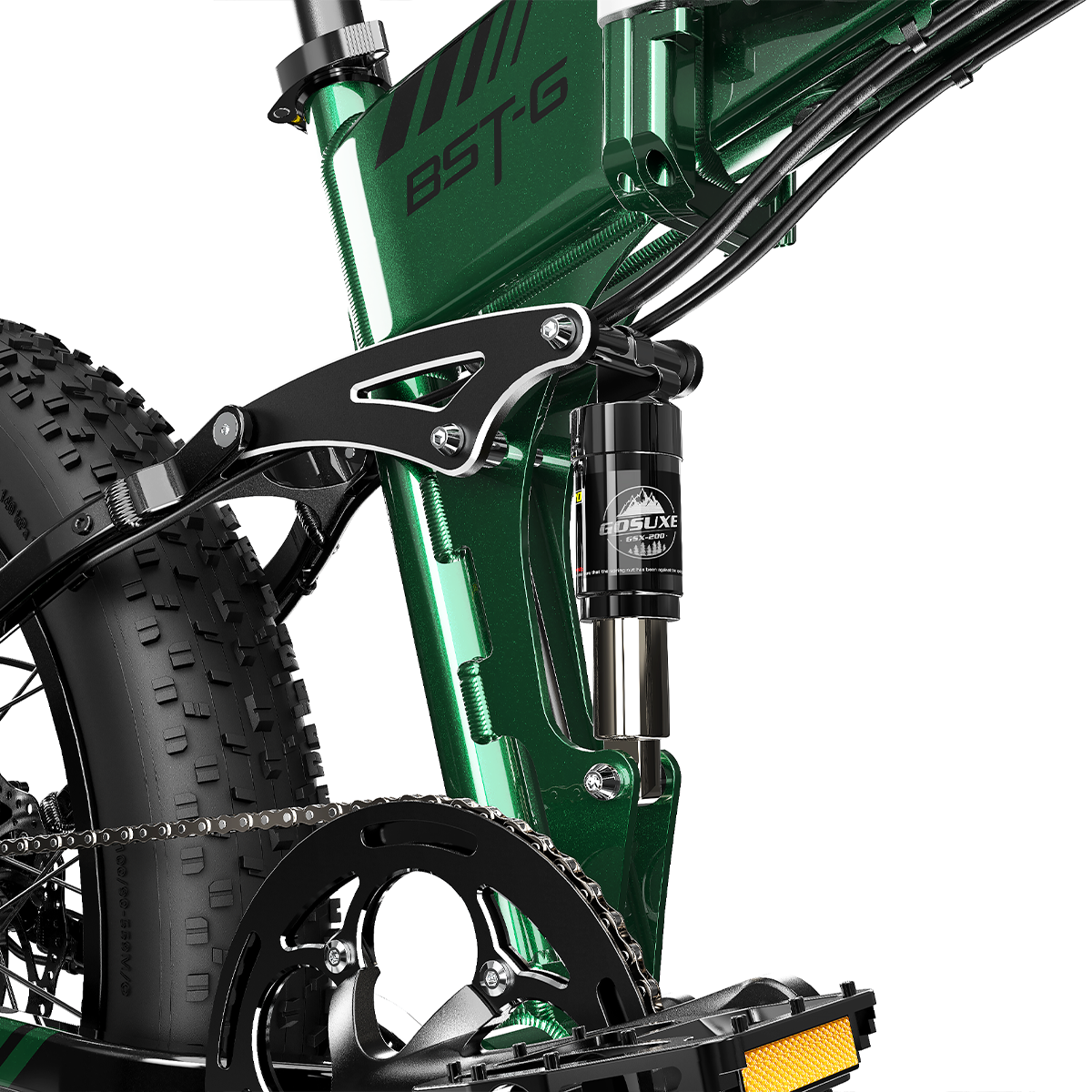 Zbliżenie zielonej ramy roweru BST-G z czarnym łańcuchem, oponą i systemem zawieszenia. Żółty odbłyśnik pedału.
