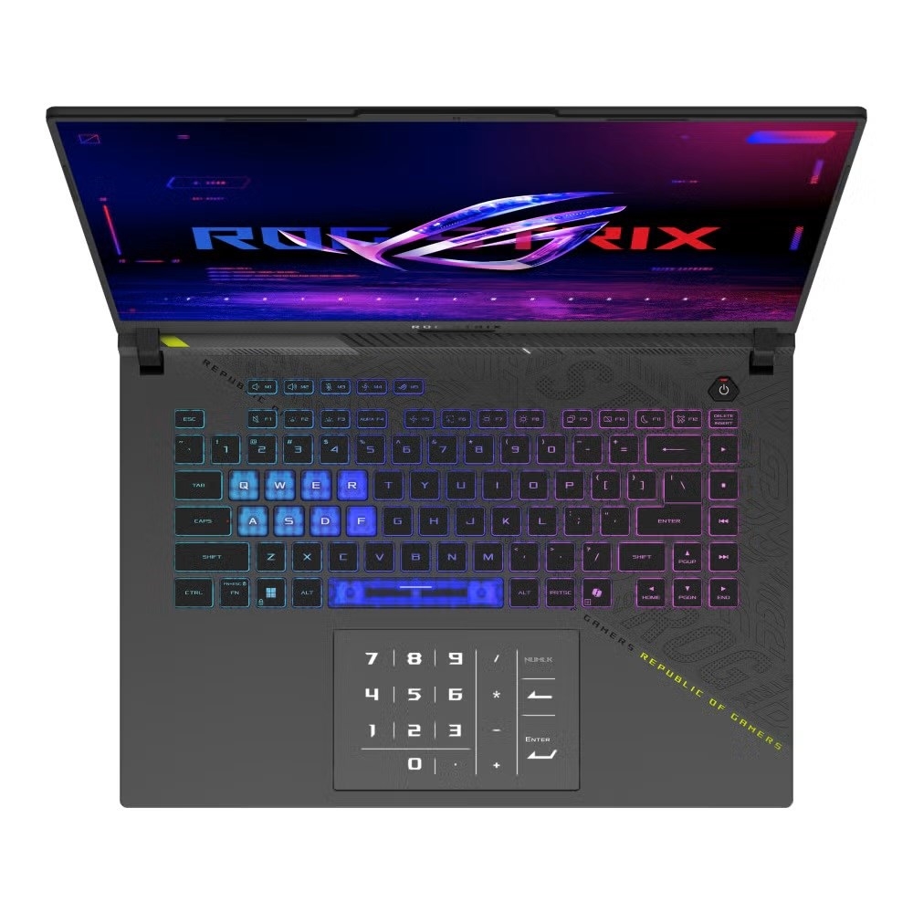 Otwarty laptop, klawiatura podświetlana RGB. Ekran wyświetla logo. Poniżej klawiatura numeryczna i touchpad. Urządzenie to ROG.