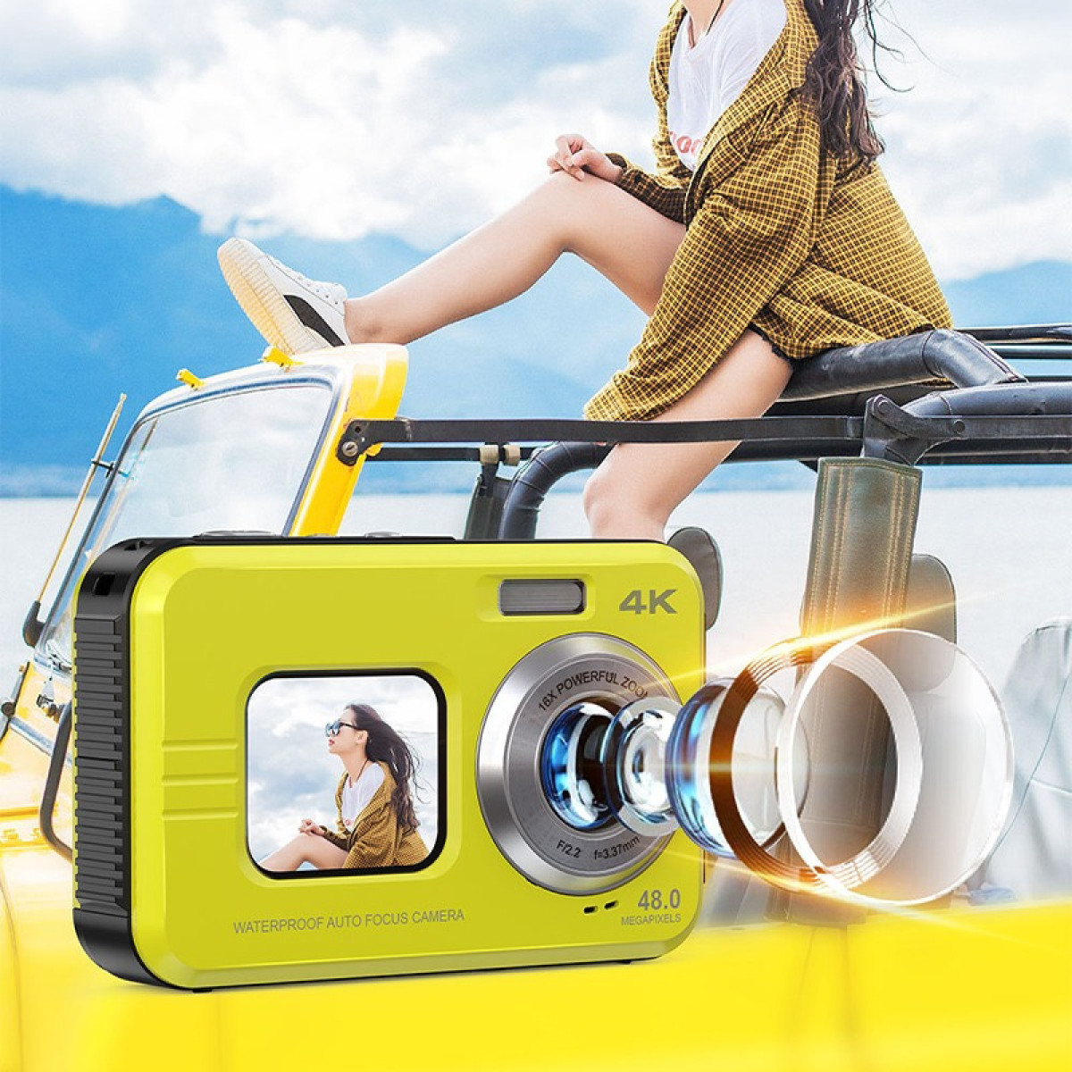 Una fotocamera gialla con l'immagine di una donna sullo schermo, una persona seduta su un'auto e il mare.