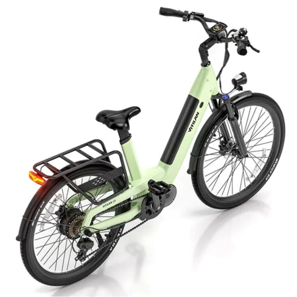 Una bicicleta eléctrica con cuadro verde claro, neumáticos negros y asiento negro. Tiene portaequipajes y faro.