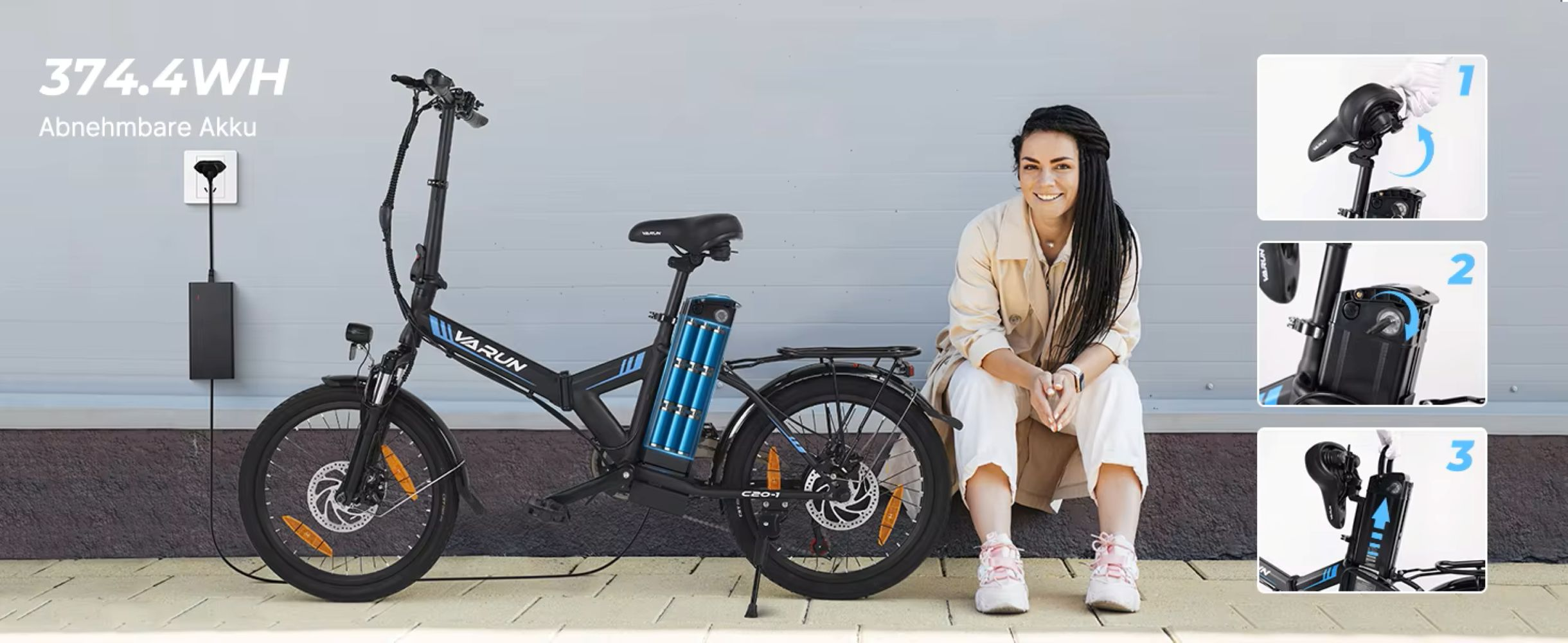 Una mujer está sentada junto a una bicicleta eléctrica. La bicicleta es negra con detalles azules, y hay un cargador enchufado.