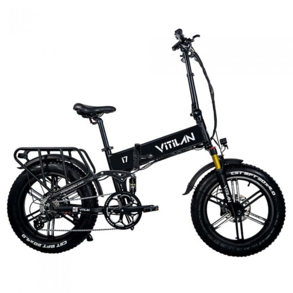 Una bicicleta eléctrica Vitilan negra. Tiene neumáticos anchos, un portaequipajes trasero y la marca visible en el cuadro. Está aislada sobre blanco.