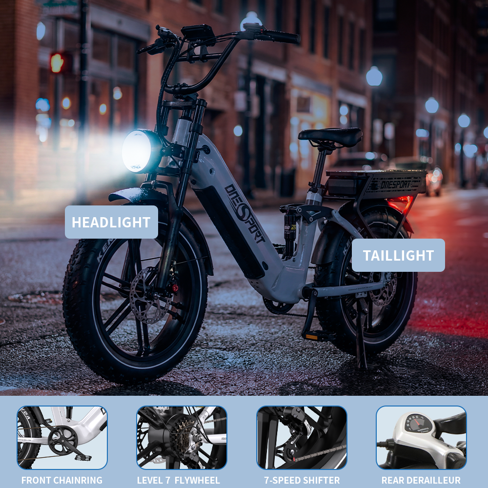 Una bicicleta eléctrica estacionada en una calle de noche. Tiene faro, luz trasera y detalles como el plato y el cambio de 7 velocidades.