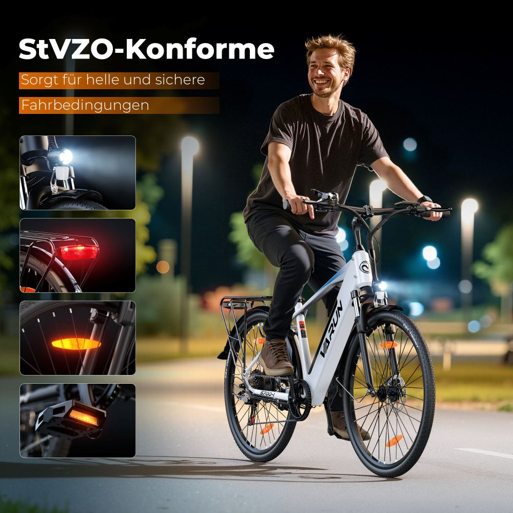 Un hombre monta una bicicleta eléctrica blanca por la noche. La bicicleta tiene luces encendidas. El fondo muestra farolas y un cielo oscuro.