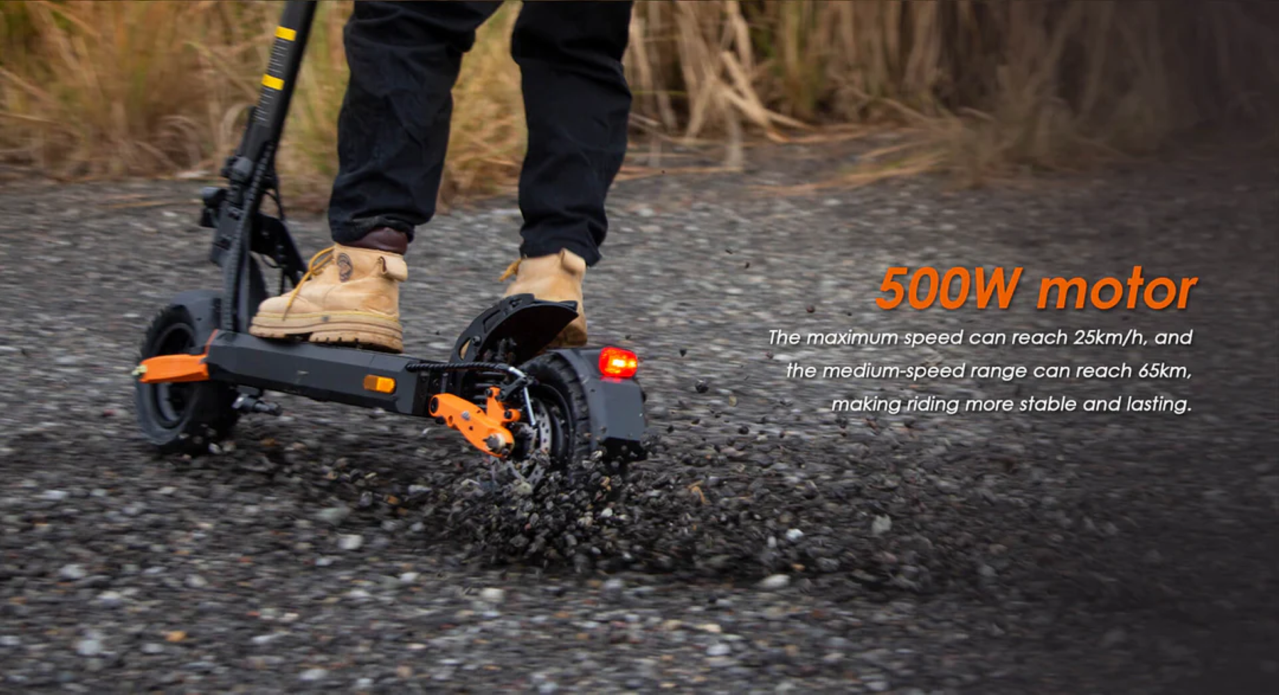 Una persona monta en un scooter eléctrico en un camino de grava. El scooter es negro y naranja. La persona lleva botas color canela.