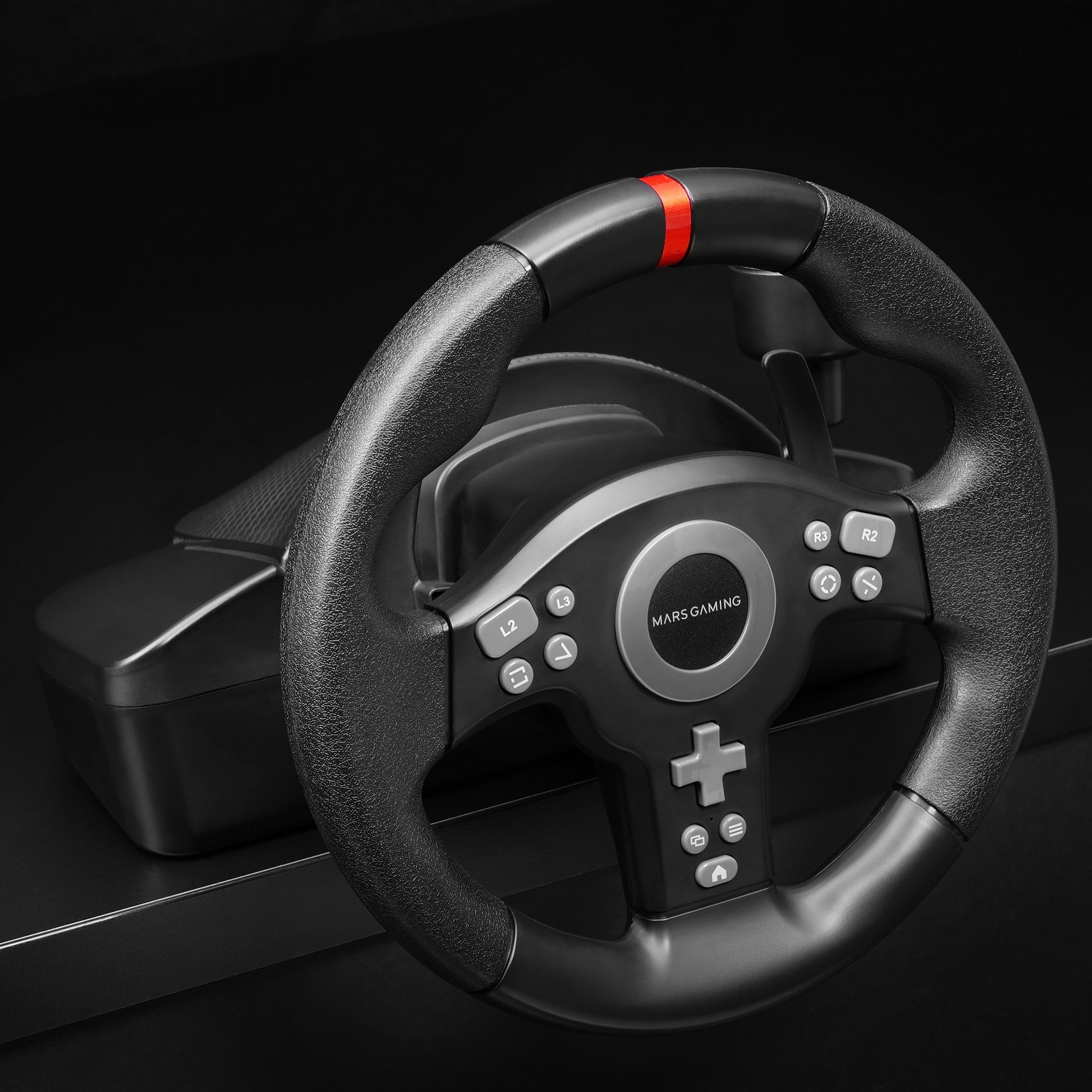 Volante de juego con botones y una franja roja, plástico negro, sobre una superficie negra. La marca es Mars Gaming.