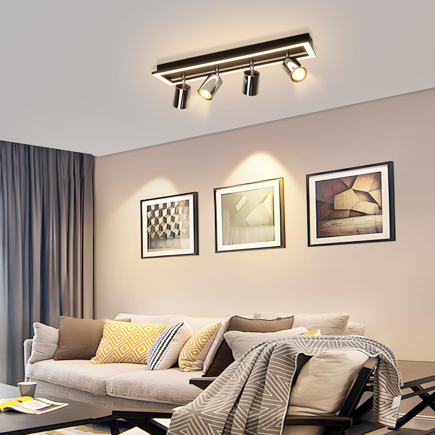 Soggiorno con divano, arte incorniciata e lampada da soffitto. Cuscini sul divano, coperta su una sedia. Muri e tende neutre.