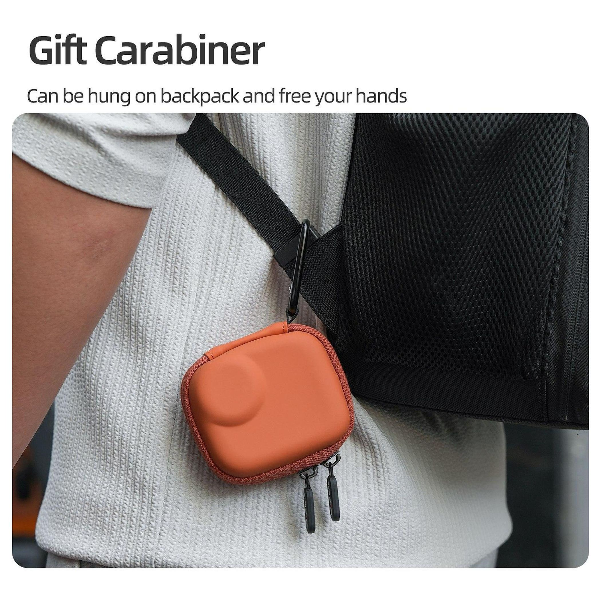 Ein orangefarbenes Etui hängt an einem Karabiner an einem schwarzen Rucksackriemen. Person trägt ein weißes Hemd. Text: Geschenkkarabiner