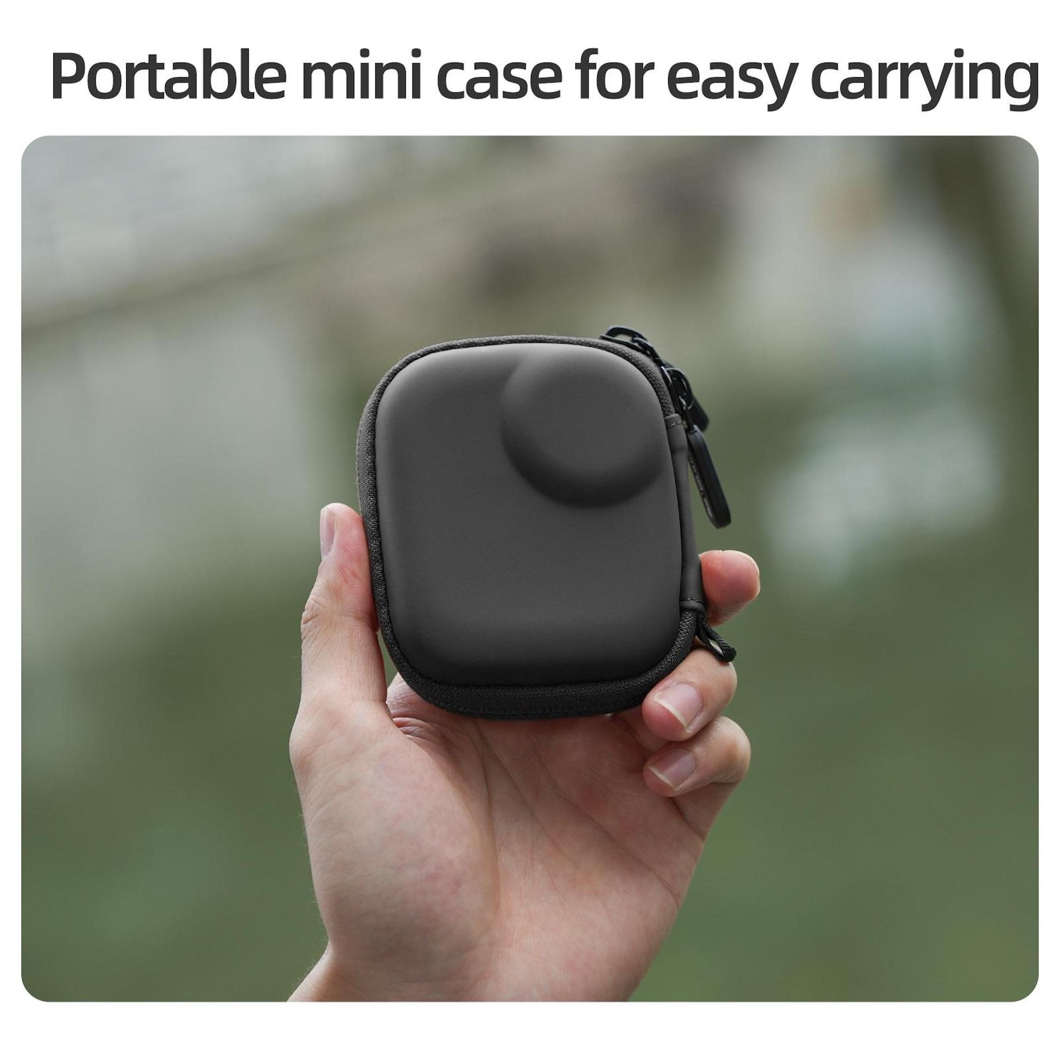 Eine Hand hält eine graue Mini-Tasche mit Reißverschluss vor verschwommenem grünem Hintergrund.