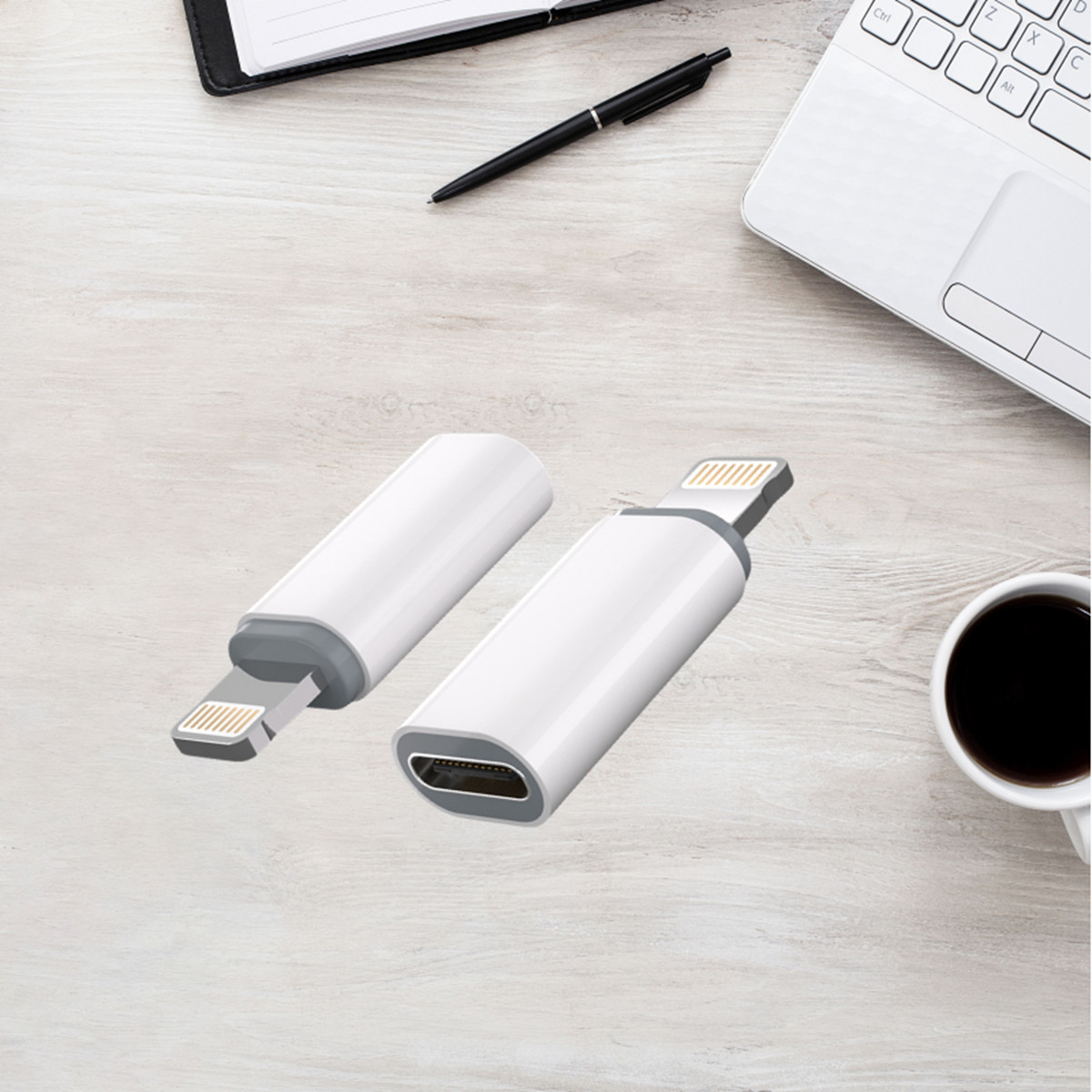 Zwei weiße und graue USB-C-Adapter auf einem Holztisch mit Laptop, Kaffee, Stift und Notizbuch.