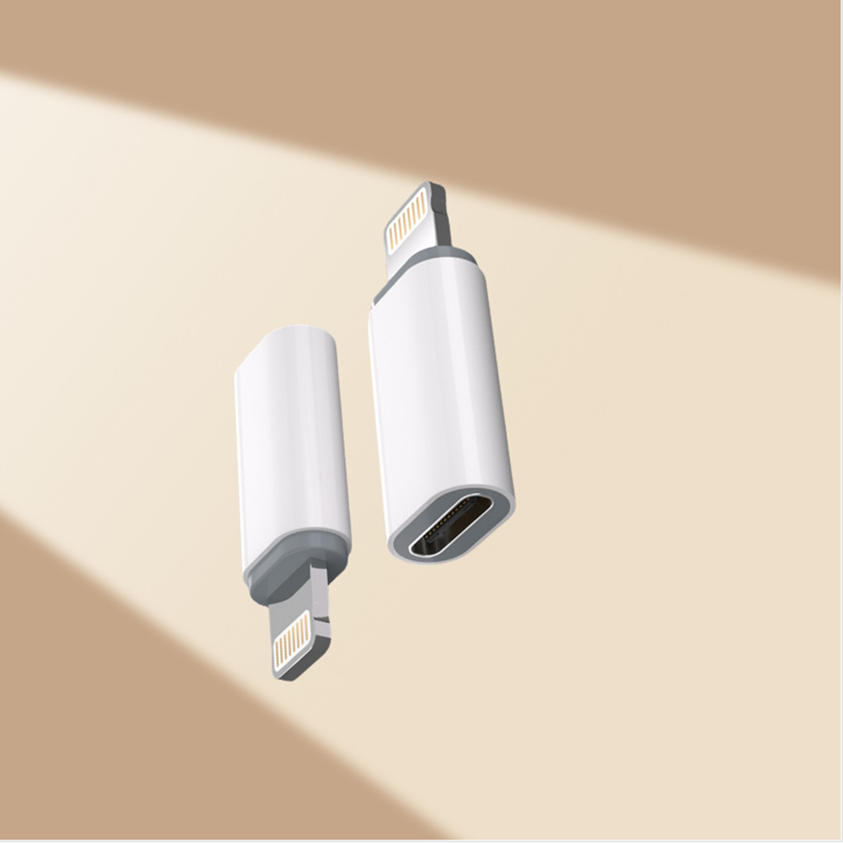 Zwei weiße und graue USB-C-auf-Lightning-Adapter auf einer beigefarbenen Oberfläche mit Schatten.