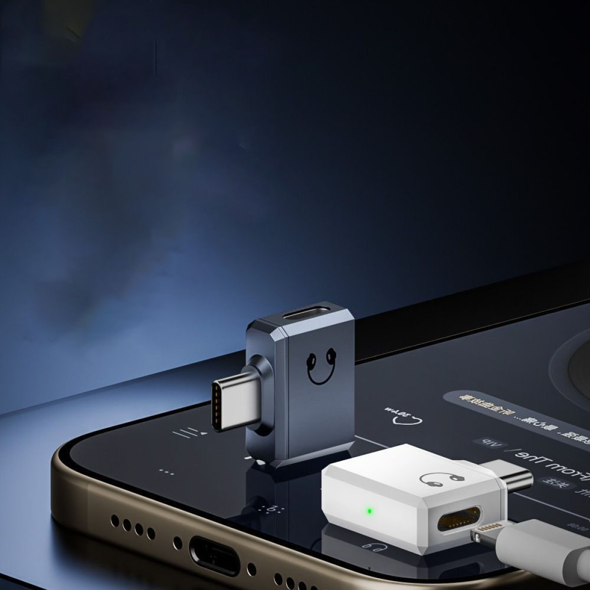 Zwei Audioadapter auf einem Telefon. Einer ist grau mit Smiley, der andere weiß. Beide sind eingesteckt.