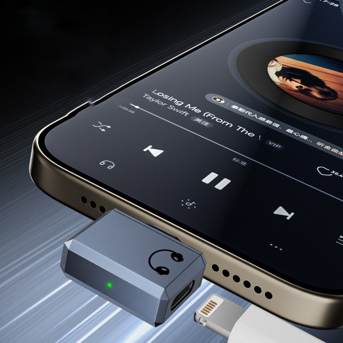 Ein Smartphone, das Musik abspielt, ist mit einem grauen Audioadapter verbunden. Ein Lightning-Kabel ist eingesteckt. Songtitel ist 'Losing Me'.