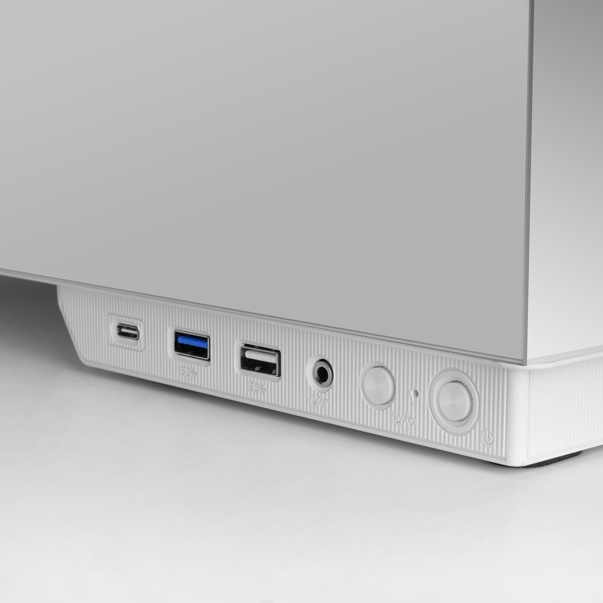 Una caja de computadora blanca con varios puertos: USB, audio y botones de encendido. Un diseño minimalista.