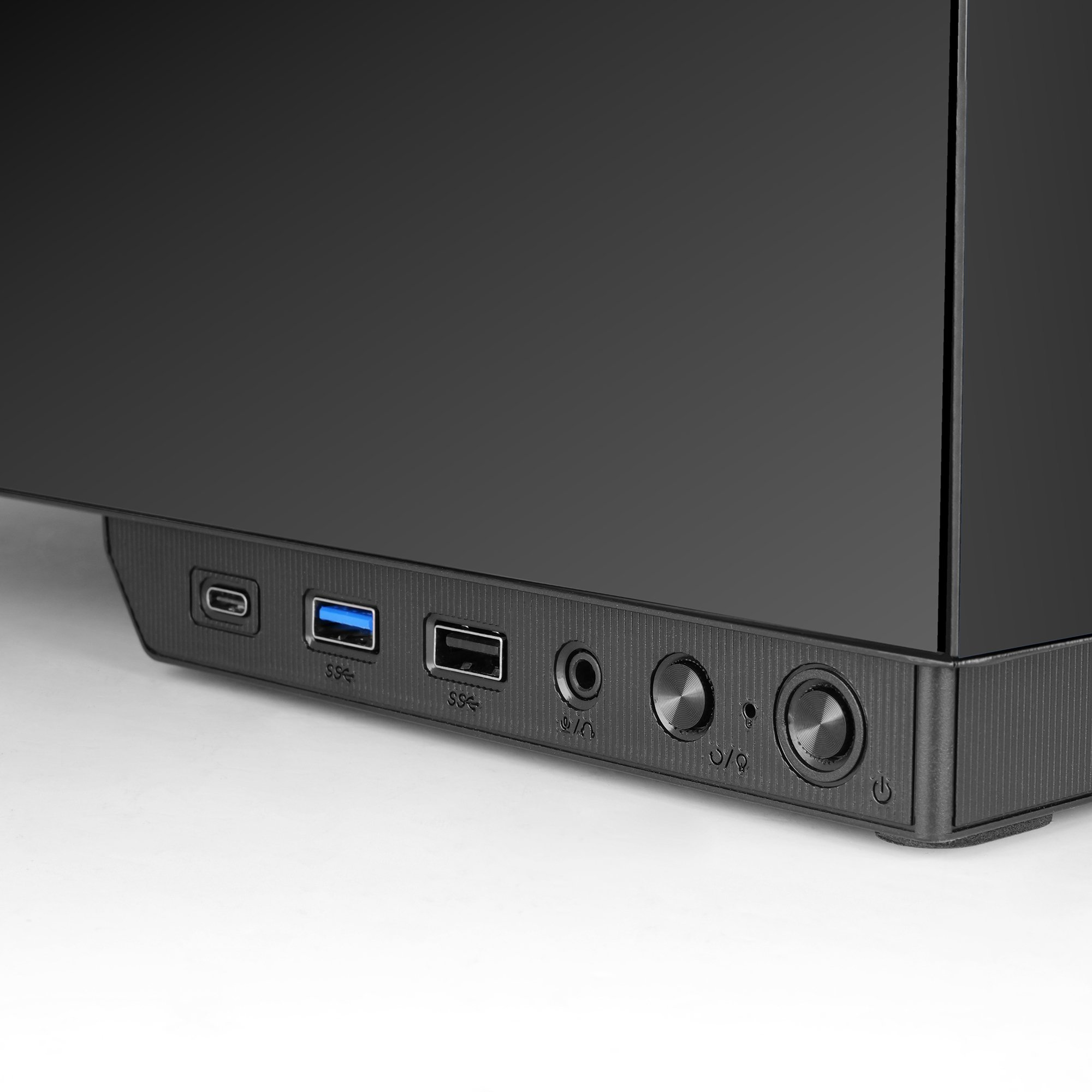 Zbliżenie na przód czarnej obudowy komputera. Ma porty USB, gniazda audio i przyciski zasilania.