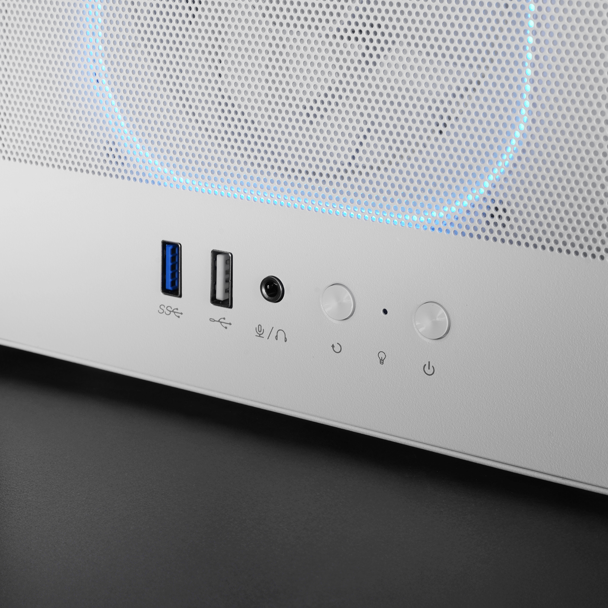Parte frontal de la carcasa blanca de la computadora con puertos, botones y una parte superior perforada con iluminación azul.
