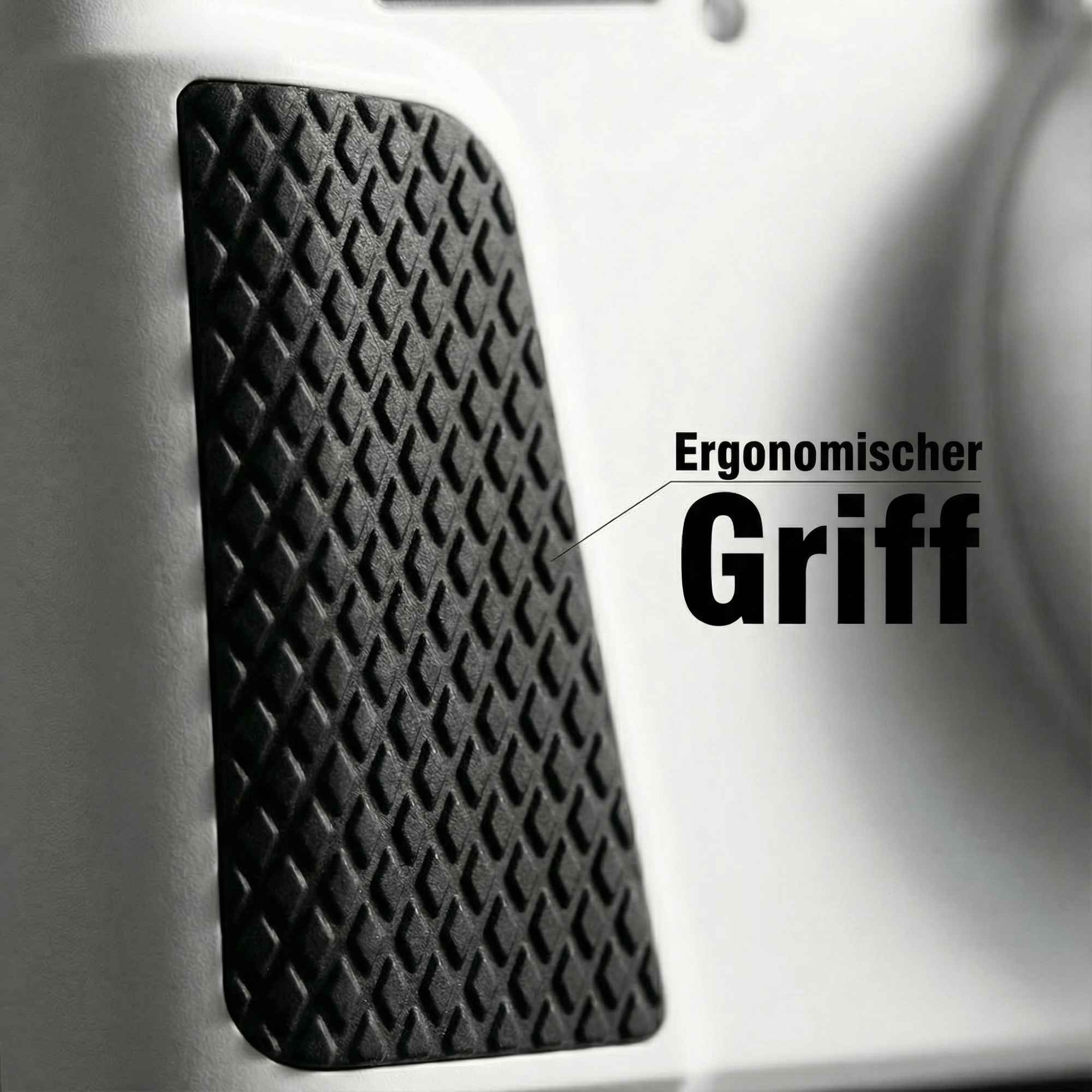 Nahaufnahme eines schwarzen strukturierten Griffs mit Rautenmuster auf weißer Oberfläche. Text: 'Ergonomischer Griff'.