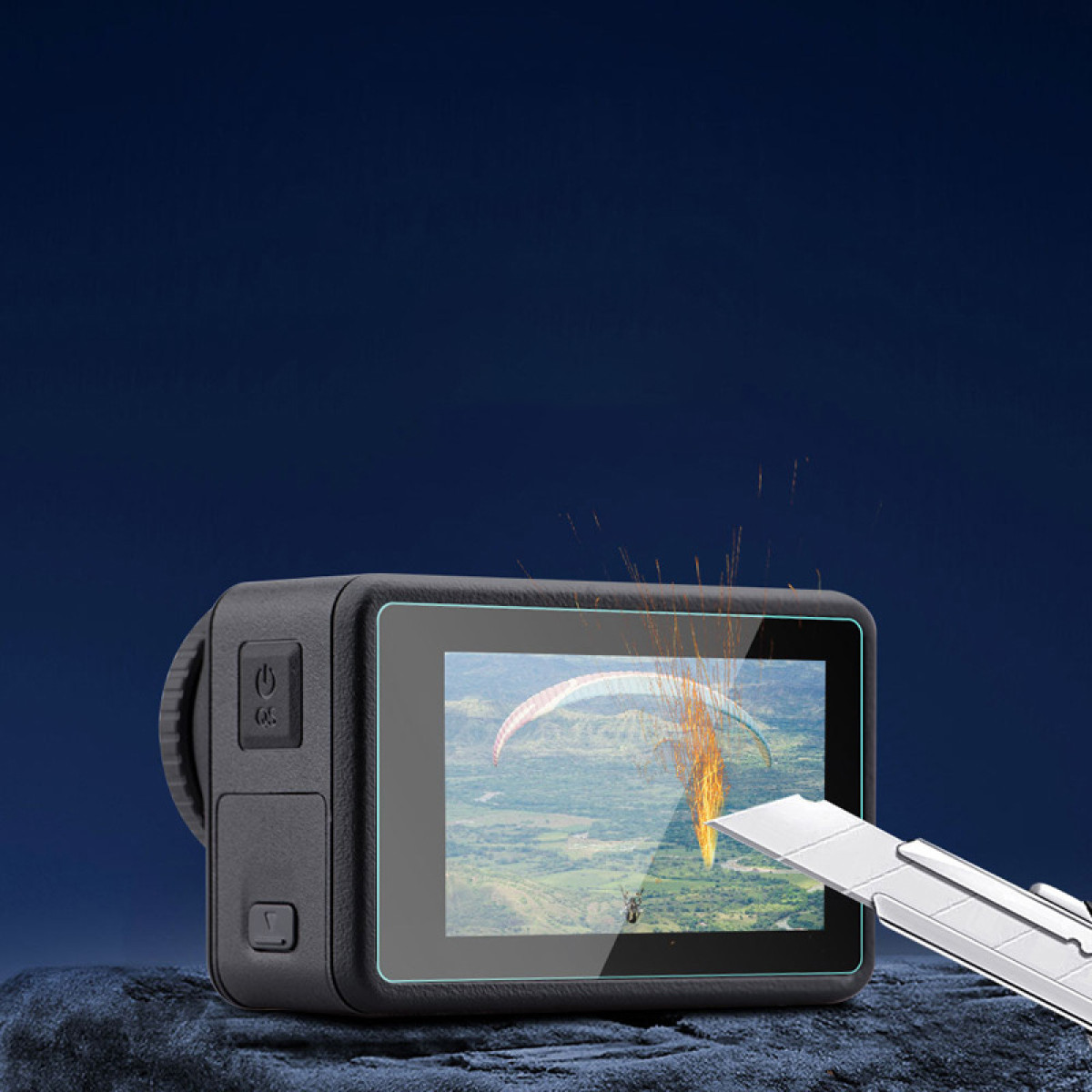 Una action cam con schermo che mostra un parapendio viene tagliata da un taglierino. Scintille che volano.