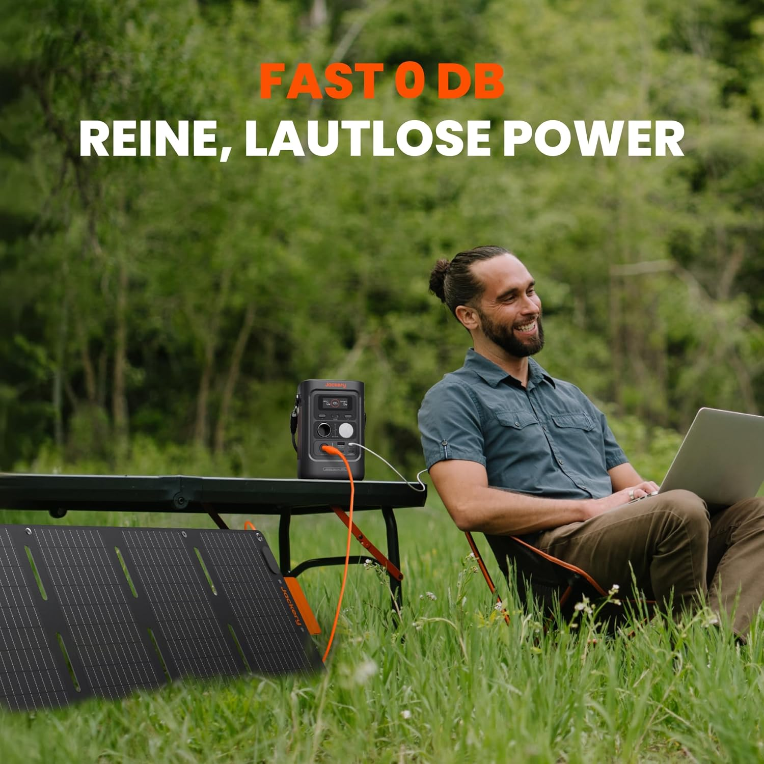 Mann mit Laptop lächelt in der Nähe von Solarpanel und Powerstation in der Natur. Text: 'FAST O DB, REINE, LAUTLOSE POWER'.