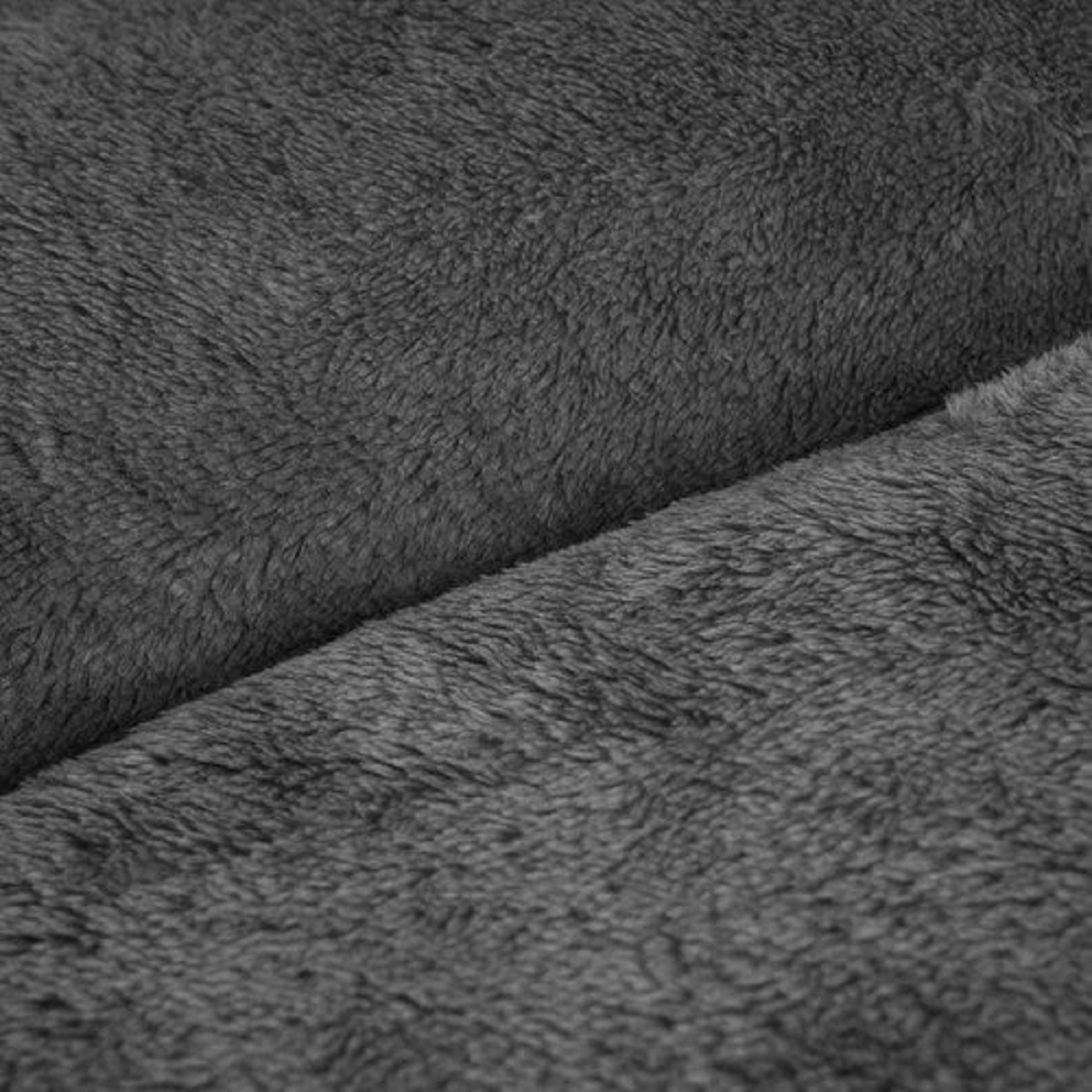 Primer plano de una tela suave y gris. La textura es esponjosa, con una costura diagonal. La tela parece afelpada y cálida.