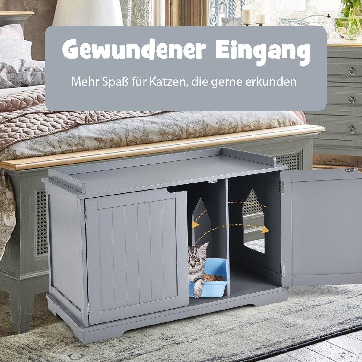 Una casa para gatos gris con la puerta abierta. Un gato está dentro cerca de una caja de arena azul. Muebles de dormitorio en el fondo.