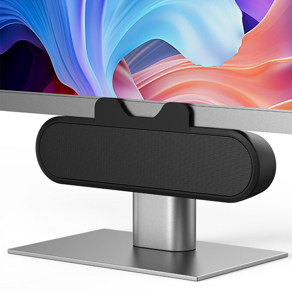 Ein Computermonitor mit angeschlossenem Lautsprecher. Der Monitor hat einen farbenfrohen, abstrakten Hintergrund. Der Lautsprecher ist schwarz und sitzt unter dem Bildschirm.