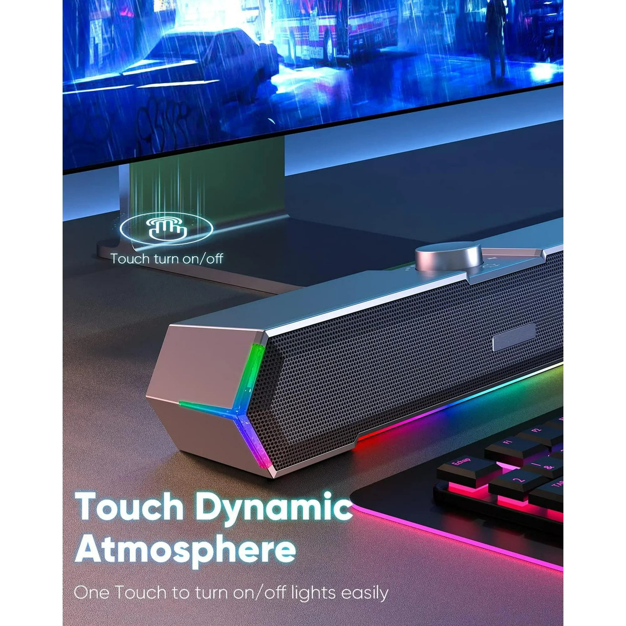 Eine Soundbar mit bunten Lichtern steht auf einem Schreibtisch in der Nähe einer Tastatur und eines Monitors.