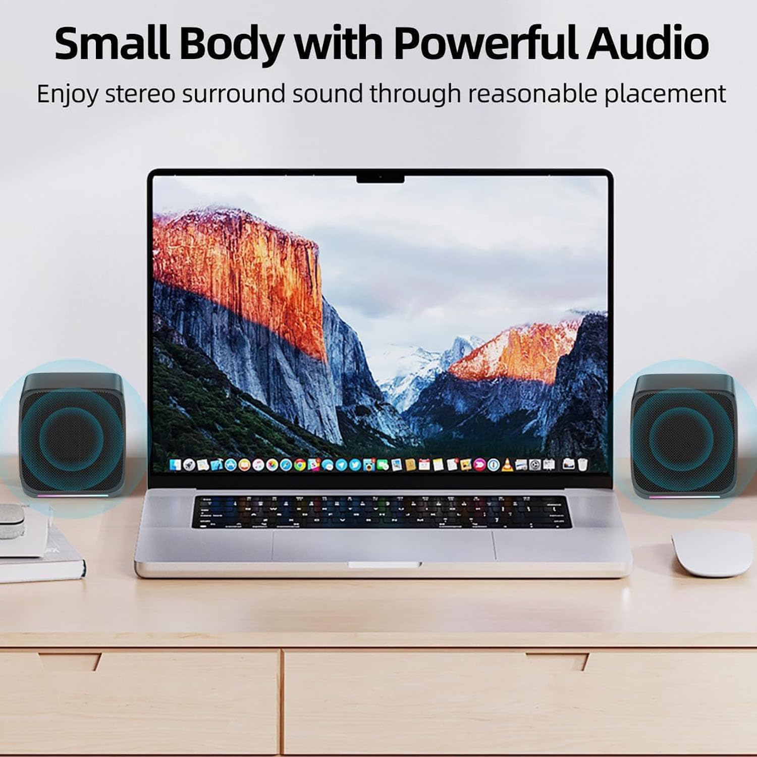 Laptop mit Bergbildschirm, zwei Lautsprecher und eine Maus auf einem Holzschreibtisch. Text sagt 'Small Body with Powerful Audio'.