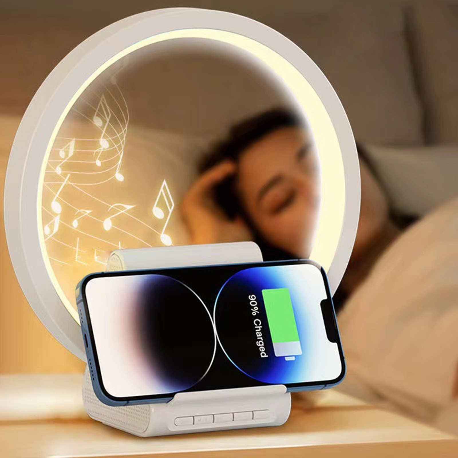 Ein Telefon, das auf einem weißen Gerät geladen wird, neben einem kreisförmigen Licht. Im Hintergrund schläft eine Person.