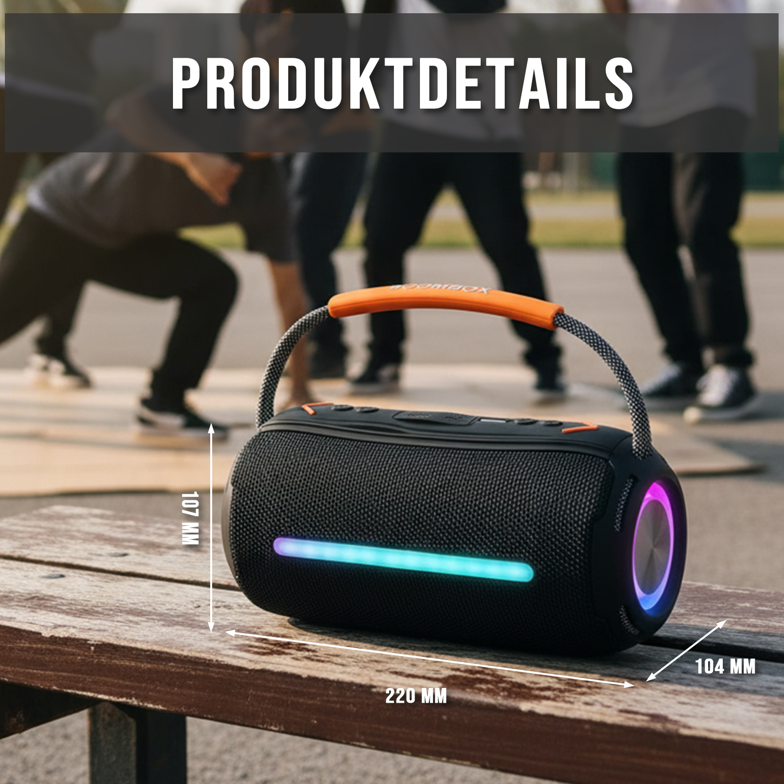 Schwarze Boombox mit orangefarbenem Griff auf einer Holzbank. Menschen im unscharfen Hintergrund. Abmessungen sind angegeben.