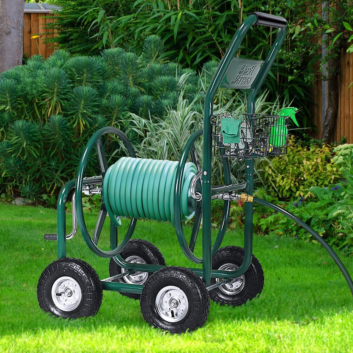 Un carro de manguera verde en un césped. Tiene una manguera, una cesta con suministros y está rodeado de vegetación.