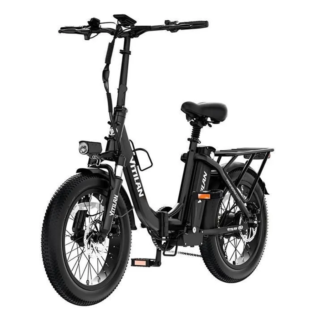Se muestra una bicicleta eléctrica negra. Tiene un manillar alto, un faro y un portaequipajes. Los neumáticos son gruesos y negros.