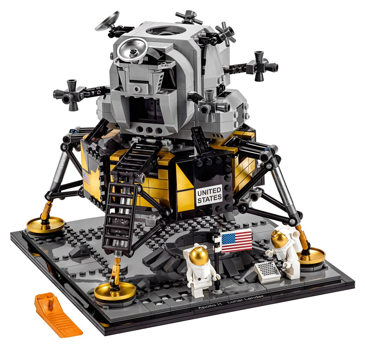 Lego Apollo 11 Mondlandermodell. Es hat eine grau-gelbe Struktur, Astronauten, eine amerikanische Flagge und eine Basis.