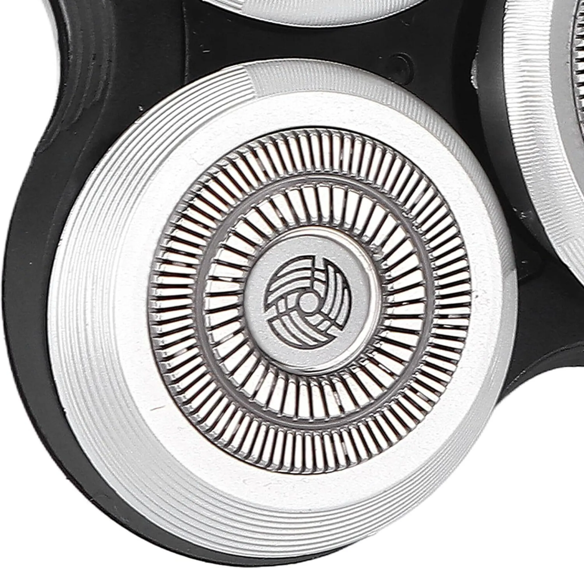 Nahaufnahme eines Rasiererkopfes. Silberne kreisförmige Klingen, schwarzer Rahmen. Detailliertes Design mit konzentrischen Ringen und einem zentralen Logo.