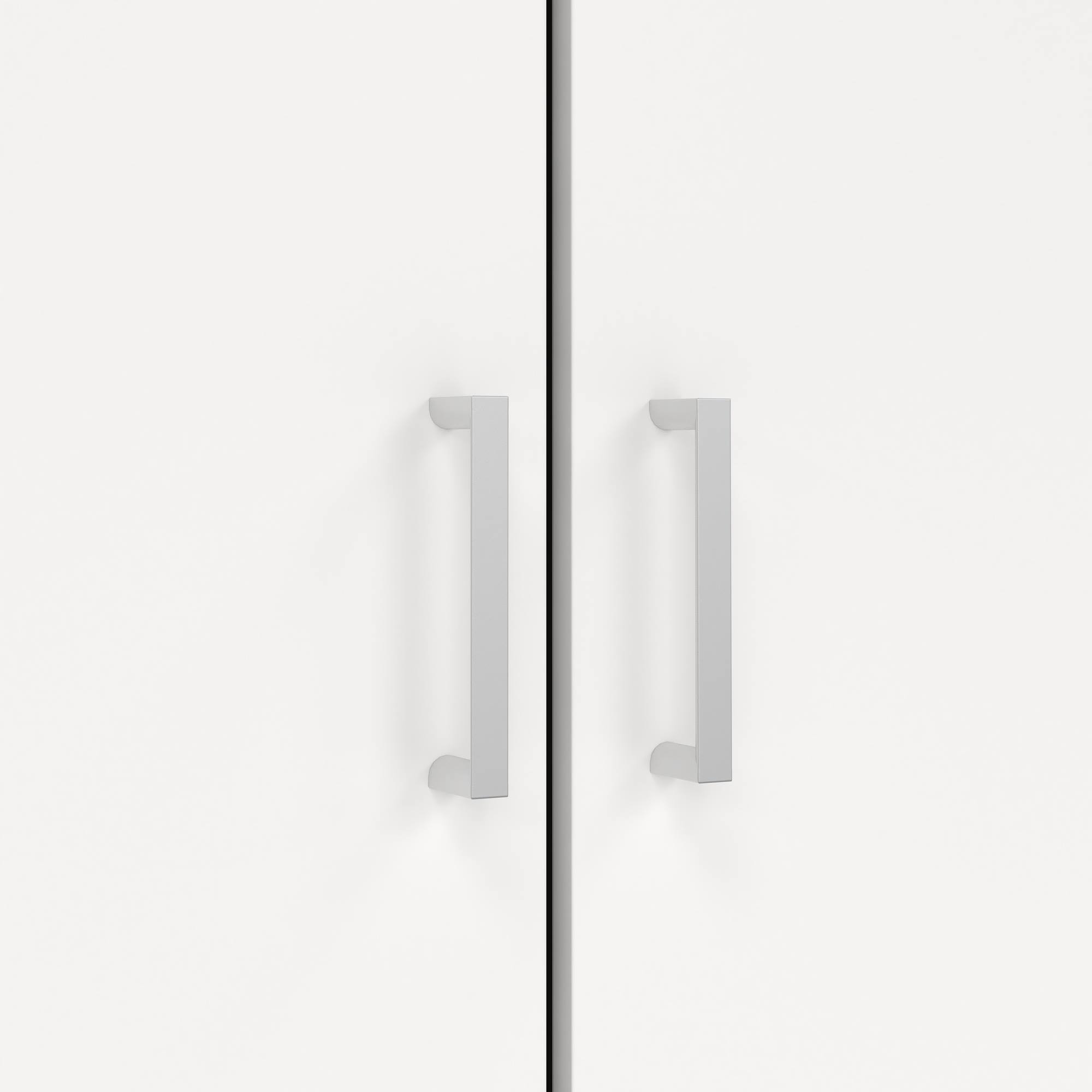 Primer plano de un armario blanco con dos puertas. Se ven dos tiradores plateados.