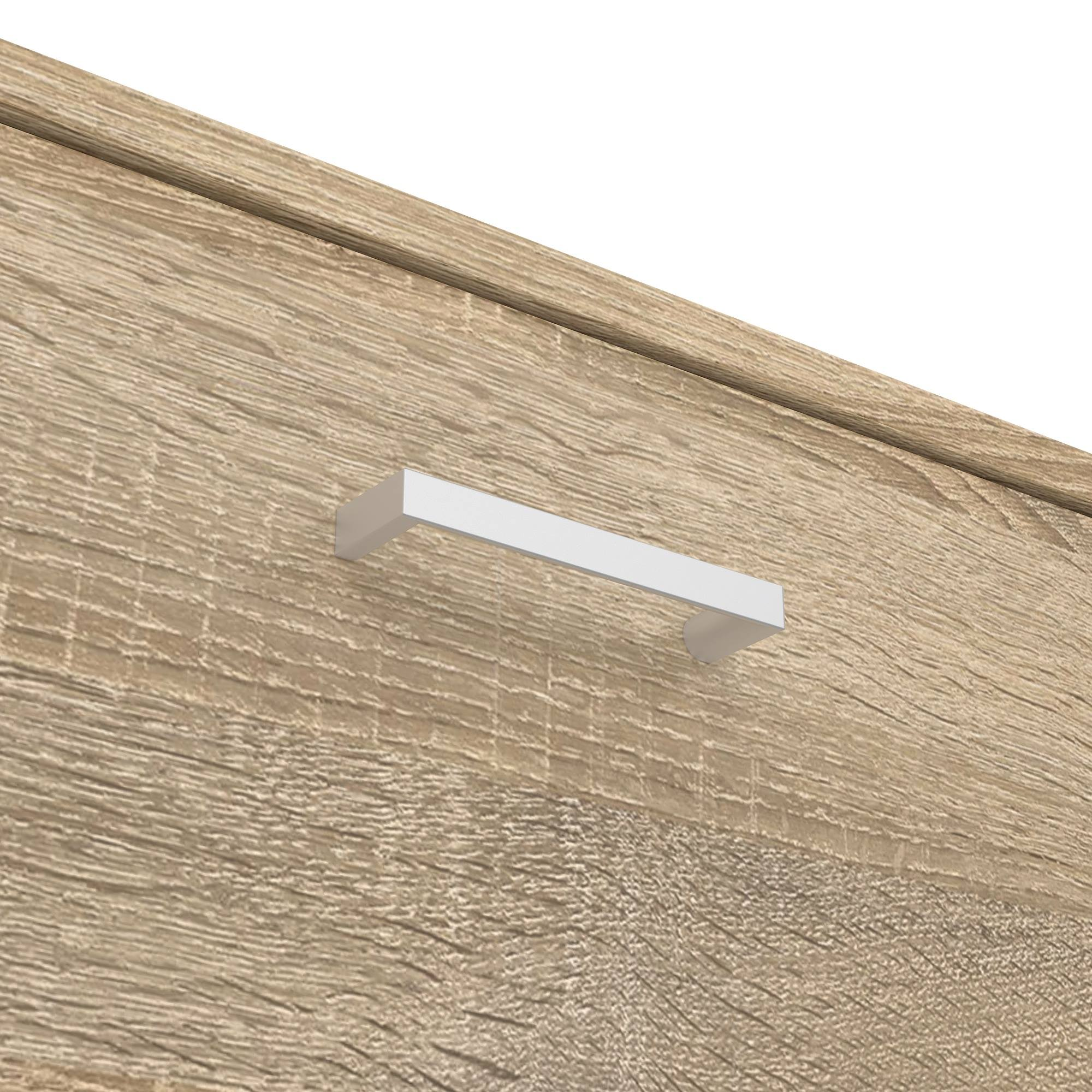 Primer plano de un armario de madera con un tirador blanco. Se ve la veta de la madera. El tirador es rectangular.