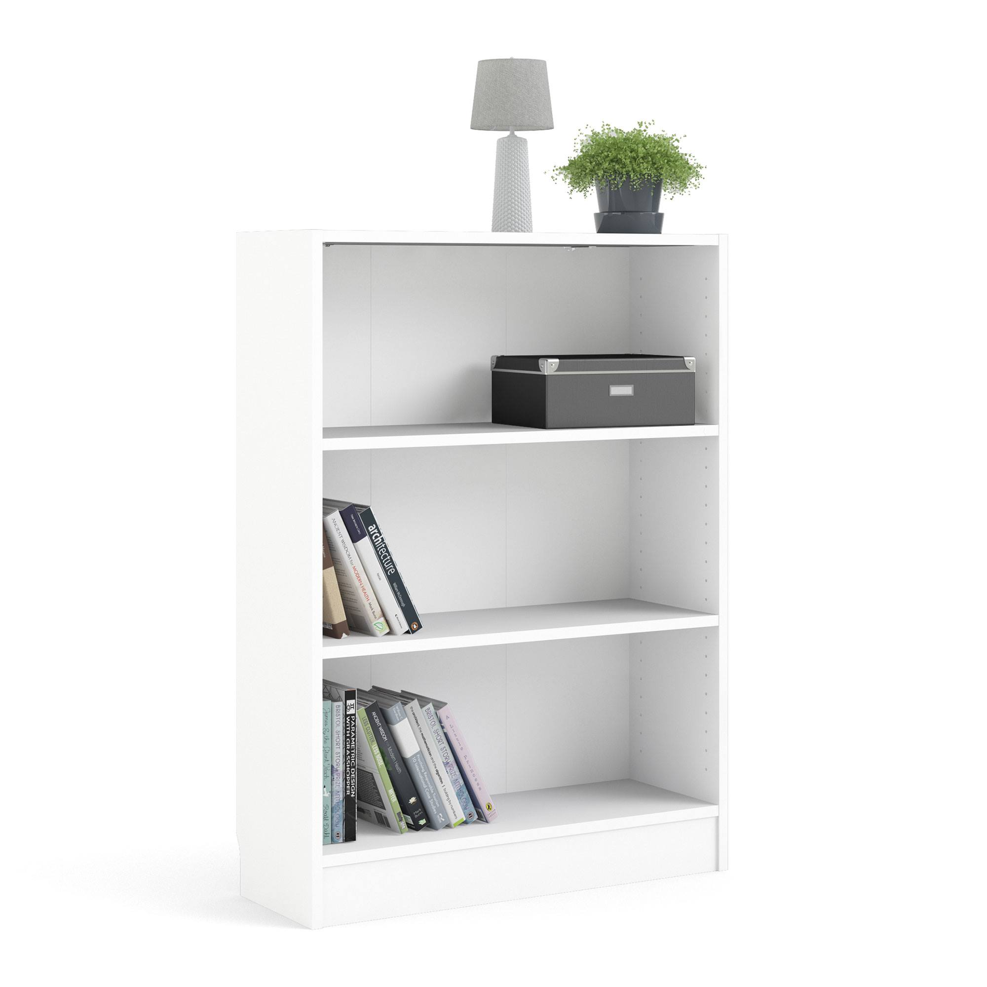 Estantería blanca con libros, una lámpara y una planta. Una caja negra está en el estante.
