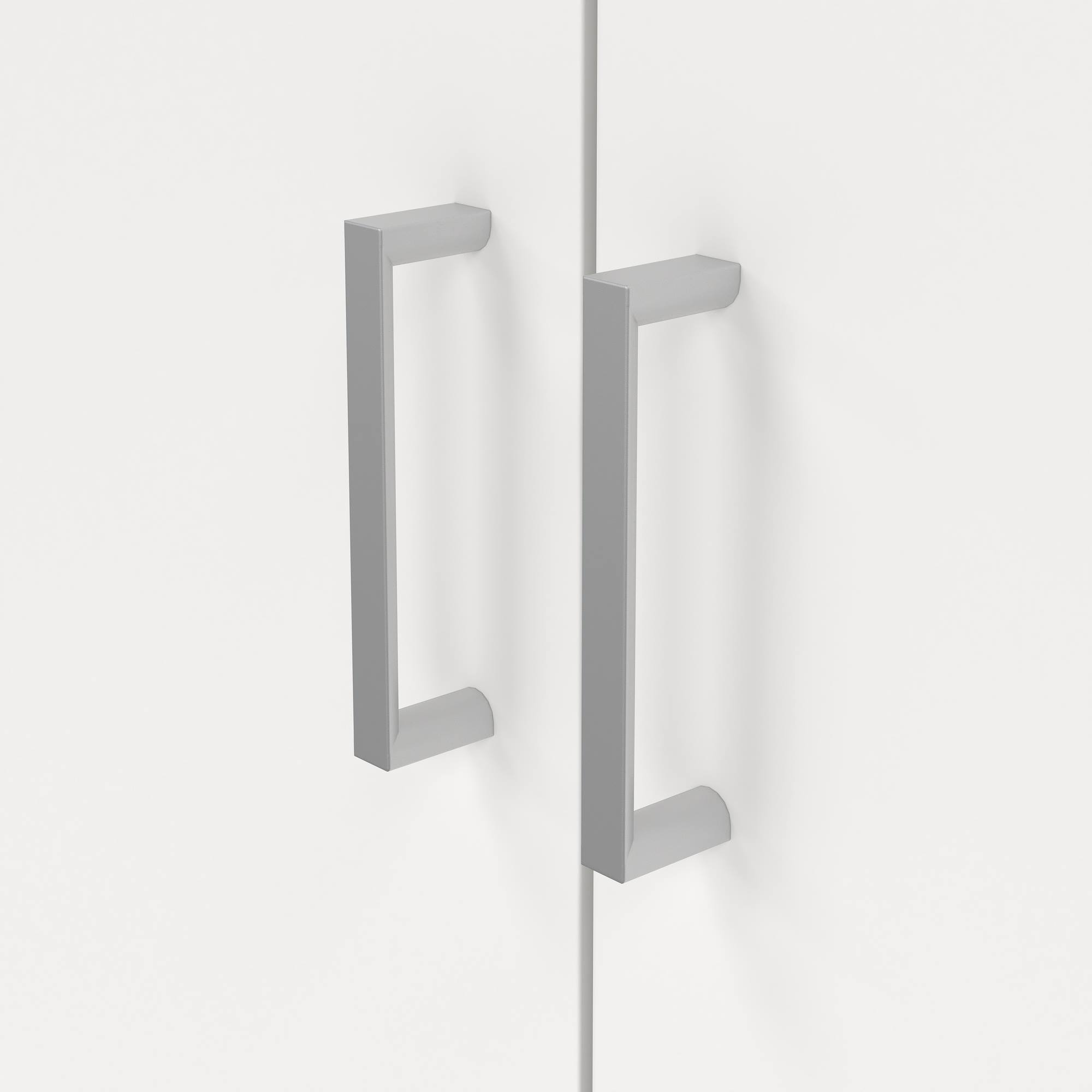 Primer plano de un armario blanco con dos tiradores rectangulares plateados en las puertas. El fondo es blanco.