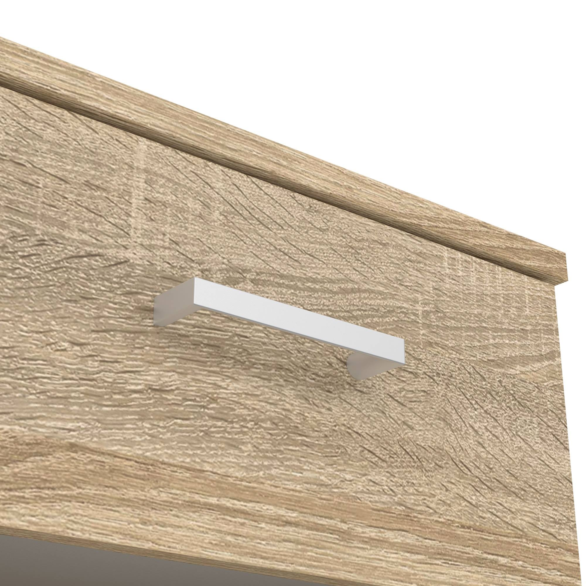 Primer plano de un armario de madera con un asa blanca. El armario tiene un acabado de vetas de madera marrón claro.