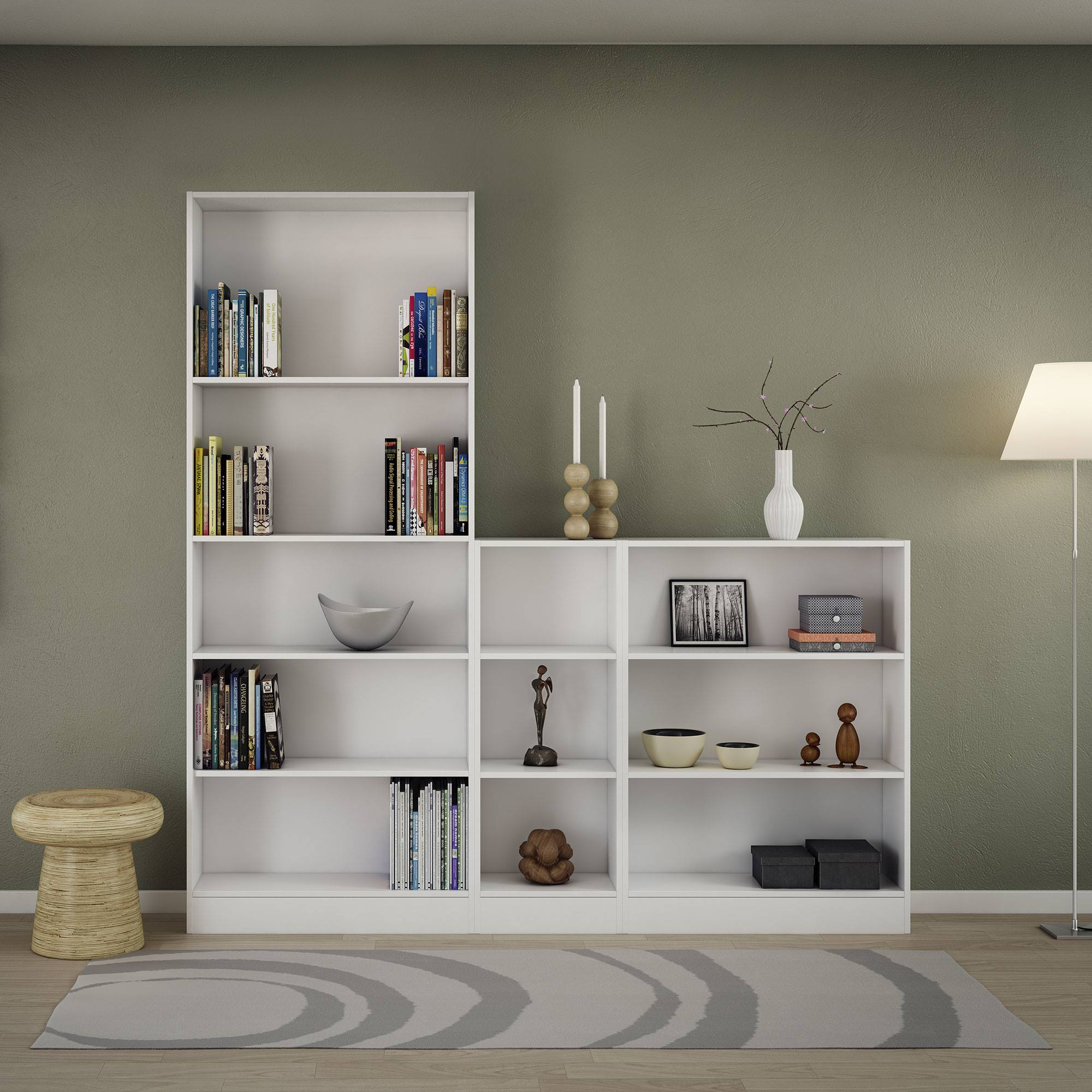 Estanterías blancas con libros y decoración contra una pared verde, una alfombra, un taburete y una lámpara.