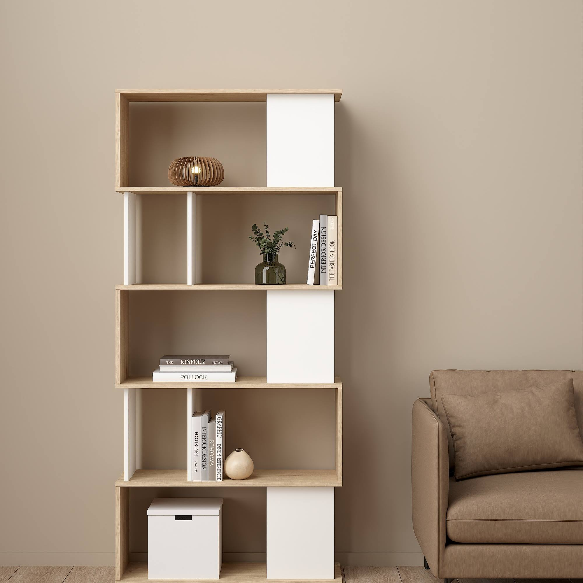 Una estantería moderna con libros y decoración. Un sofá beige está a la derecha. El fondo es una pared lisa.
