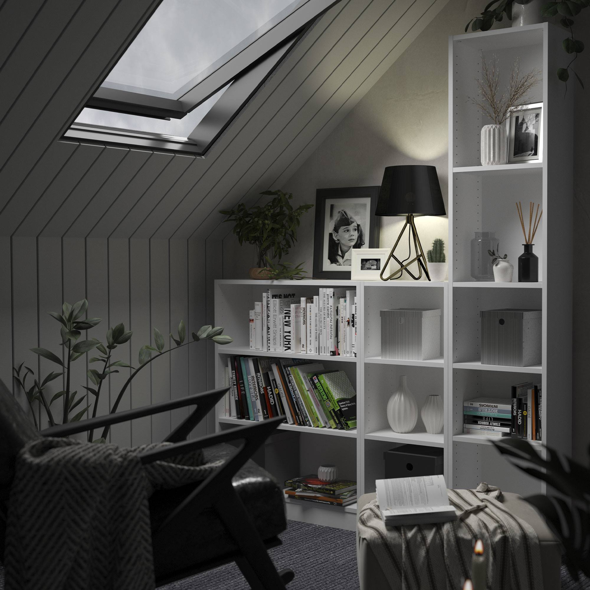 Una habitación con claraboya, estanterías, una silla y una lámpara de mesa. Libros, plantas y fotos decoran el espacio.