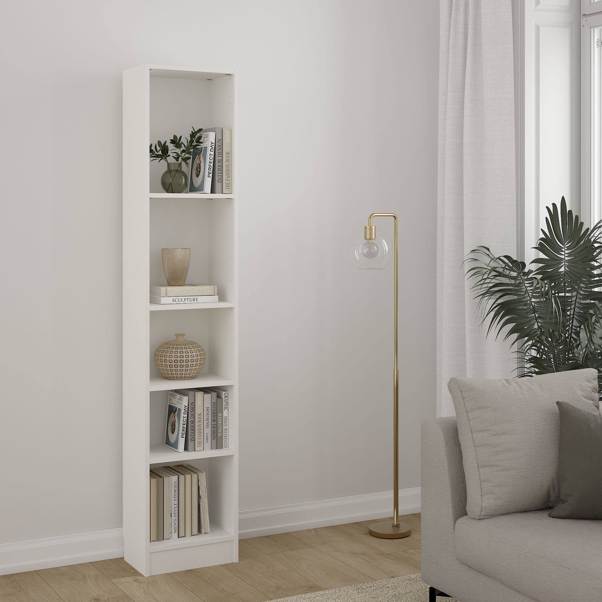 Una estantería blanca con libros y jarrones, una lámpara de pie, un sofá y plantas cerca de una ventana con cortinas.