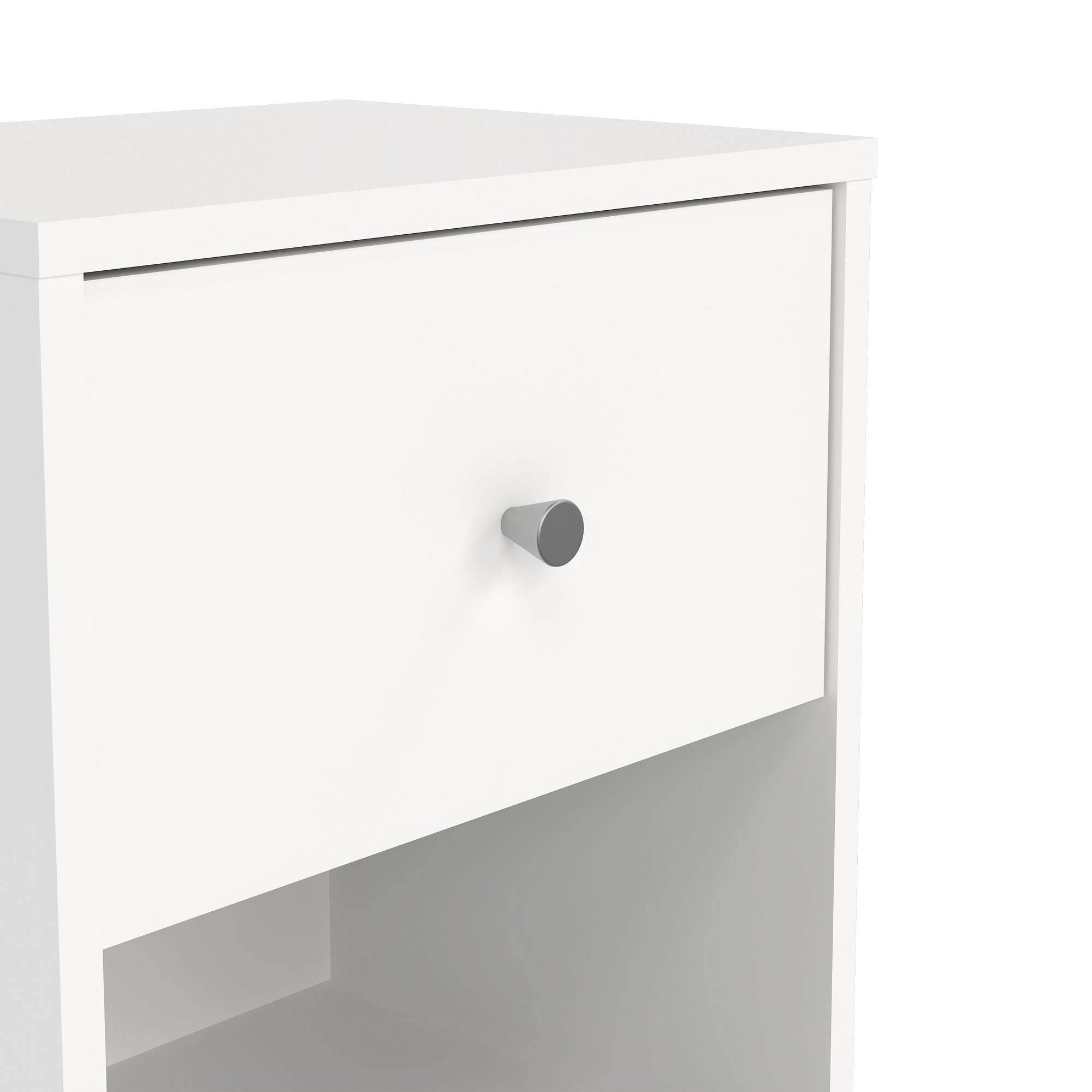 Primer plano de un cajón blanco de mesita de noche con un tirador plateado. La mesita está sobre un fondo blanco.