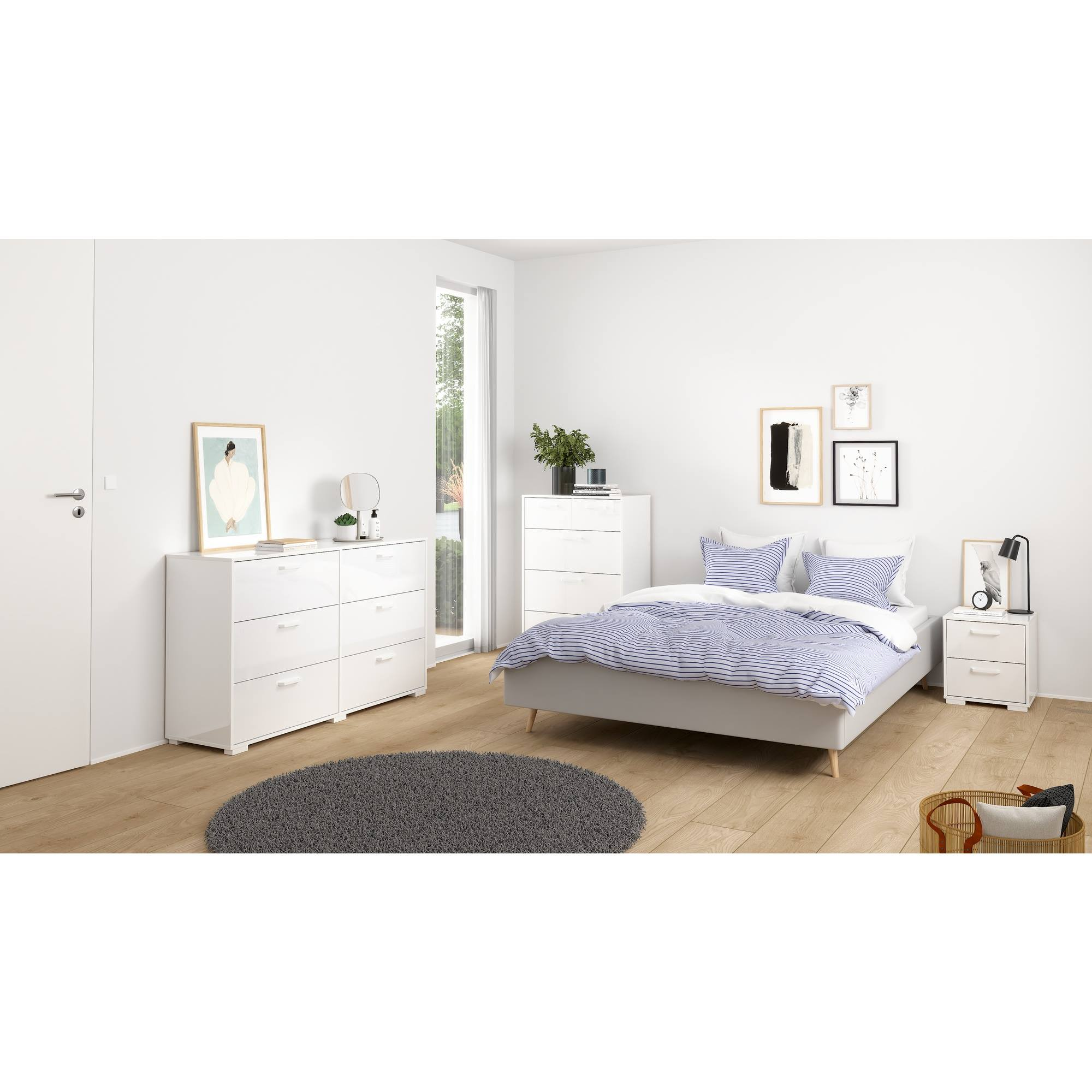 Un dormitorio con muebles blancos, una cama con ropa de cama a rayas azules, una alfombra gris y arte enmarcados. Suelo de madera.