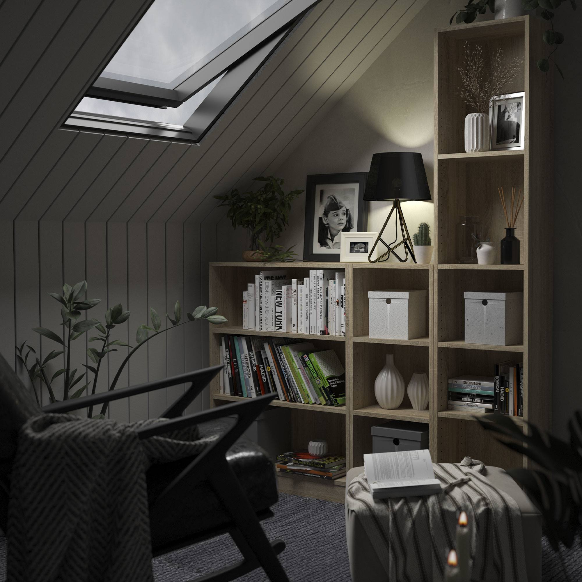Acogedora buhardilla con tragaluz, estanterías, sillón y lámpara. Libros, plantas y una mesa pequeña con velas presentes.
