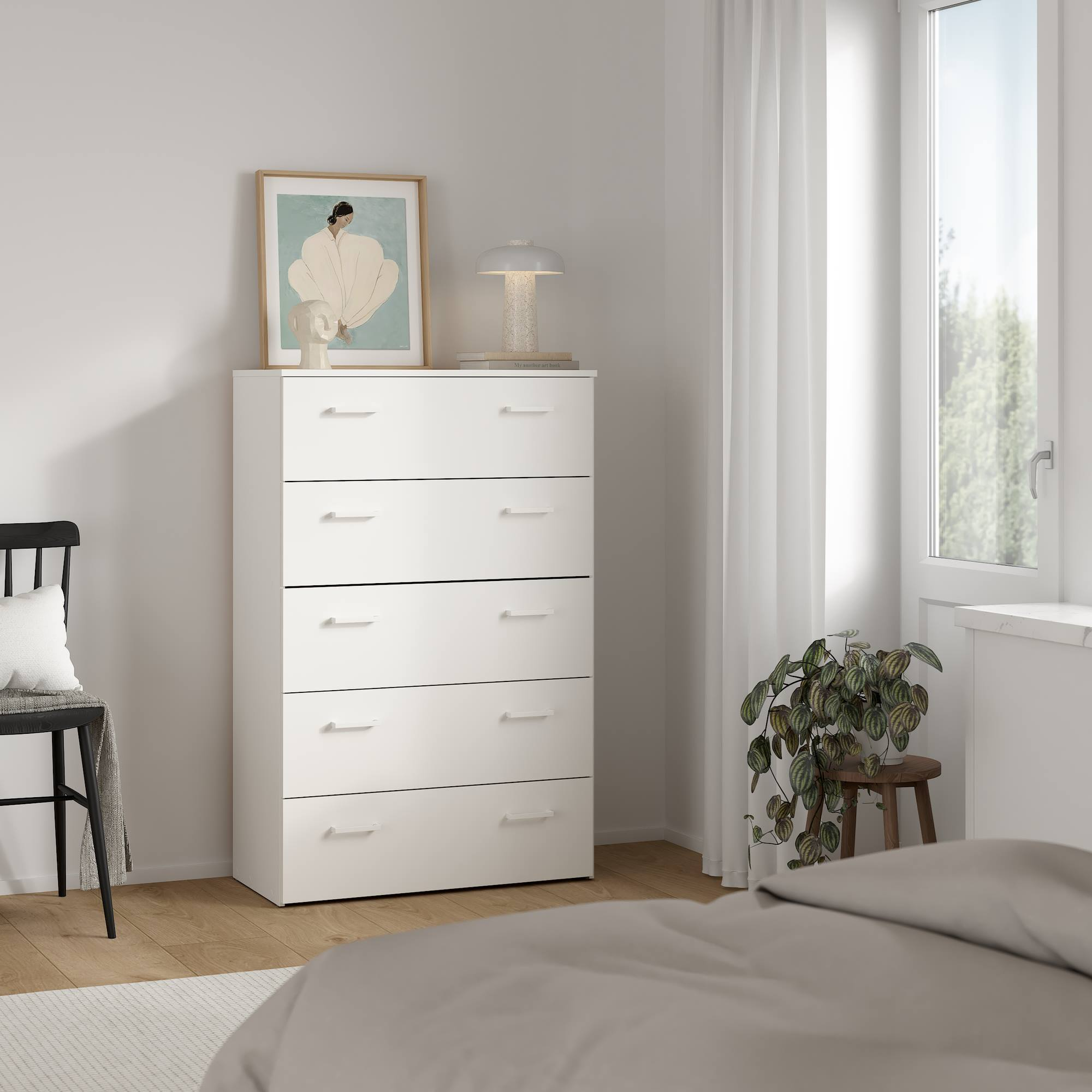 Una cómoda blanca con arte y una lámpara está cerca de una ventana con cortinas. Una planta está en un taburete. Una cama está en primer plano.